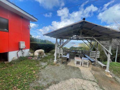 a red building with a sheep grazing under a roof at Marine View Shimane - Vacation STAY 85912v in Matsue