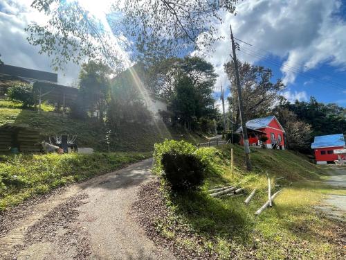 a dirt road in a field with a red house at Marine View Shimane - Vacation STAY 85912v in Matsue