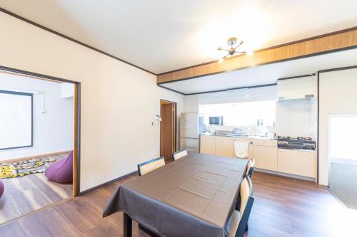 a dining room with a table and a kitchen at KANJYAKU-AN - Vacation STAY 76347v in Nakatsugawa