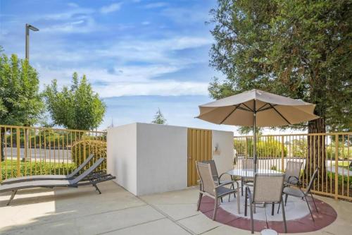 a patio with a table with an umbrella and chairs at Best Western Plus Twin View Inn and Suites in Redding