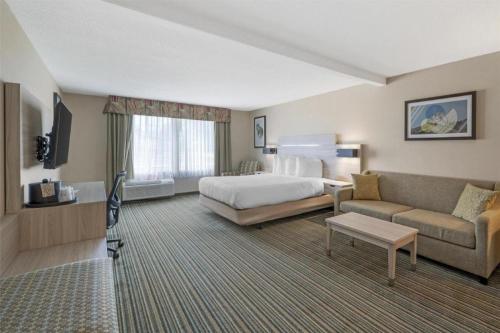 a hotel room with a bed and a couch at Best Western Plus Twin View Inn and Suites in Redding
