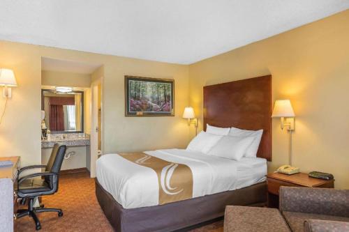 a hotel room with a bed and a chair at Quality Inn Calera I-65 exit 231 in Calera