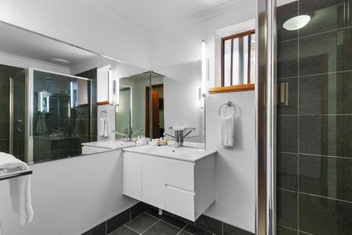 a white bathroom with two sinks and a shower at Comfort Inn & Suites Riverland in Barmera