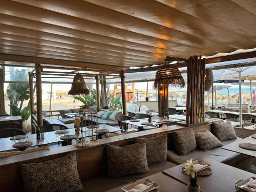 a restaurant with tables and chairs and windows at Luxury villa w seaview Cabopino in Marbella