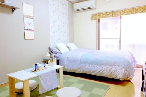 ein kleines Schlafzimmer mit einem Bett und einem Tisch in der Unterkunft Daiichi Mitsumi Corporation - Vacation STAY 14915 in Musashino
