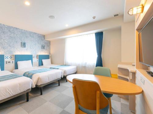 a hotel room with two beds and a table at Comfort Hotel Ishigaki Island in Ishigaki Island