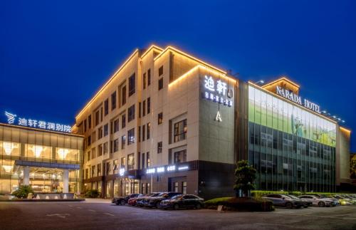 a large building with cars parked in a parking lot at Shanghai Dixuan Junlan Resort Hotel in Shanghai