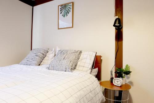 a bedroom with a white bed and a table with a clock at Daiichi Mitsumi Corporation - Vacation STAY 15348 in Musashino