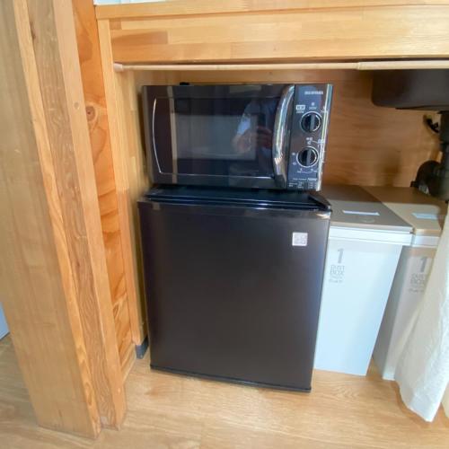 a microwave sitting on top of a refrigerator at Ｒ．Ｇａｒｄｅｎ - Vacation STAY 10552v in Yamanakako