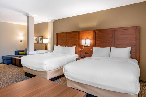 a hotel room with two beds and a table at Comfort Inn & Suites in City in the Village of Clarkson