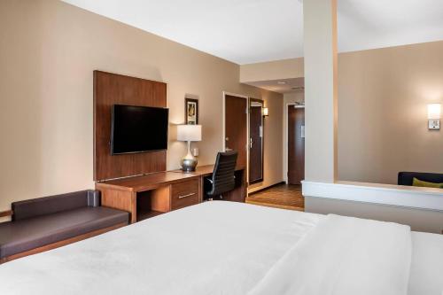 a hotel room with a bed and a flat screen tv at Comfort Inn & Suites in City in the Village of Clarkson