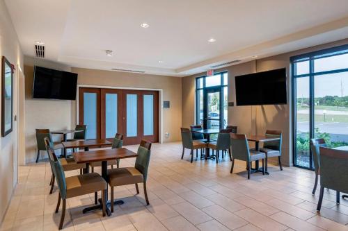 a dining room with tables and chairs and televisions at Comfort Inn & Suites in City in the Village of Clarkson