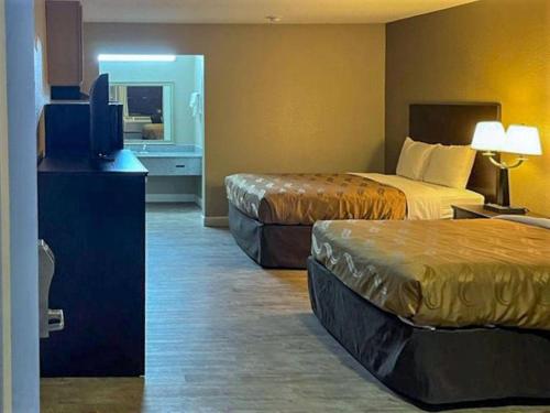 a hotel room with two beds and a flat screen tv at Suburban Studios Columbia - Harbison in Columbia