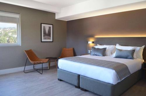 a hotel room with a large bed and a window at Radisson Hotel Curico in Curicó