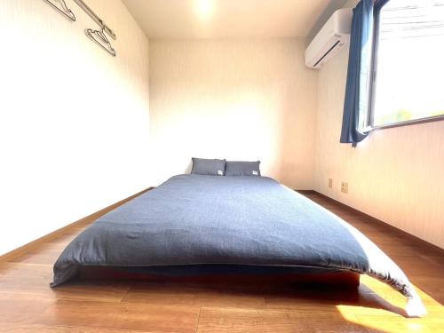 a bedroom with a large bed in a room with a window at Sapan Hasegawa - Vacation STAY 14781 in Kitakyushu