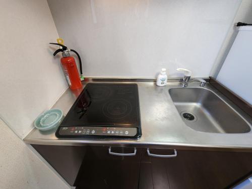 a kitchen counter with a sink and a stove at Naraha Fukujusou - Vacation STAY 89024v in Naraha