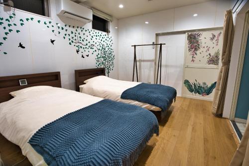 a bedroom with two beds and a wall with butterflies at racine yakushima - Vacation STAY 86828v in Ambo