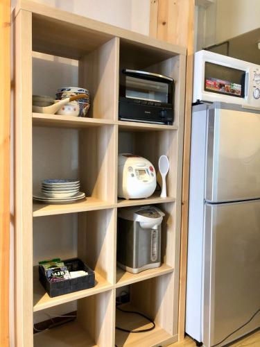 a kitchen cabinet with a refrigerator and a microwave at Maison Etoile Room 705 - Vacation STAY 14807 in Nagoya