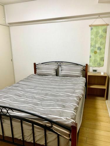 a bedroom with a bed with white sheets and pillows at Maison Etoile Room 705 - Vacation STAY 14807 in Nagoya