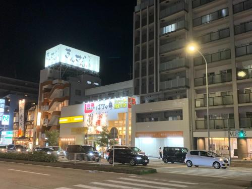 eine Stadtstraße mit Autos, die vor einem Gebäude geparkt sind in der Unterkunft Maison Etoile Room 705 - Vacation STAY 14807 in Nagoya