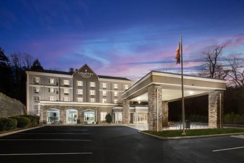 a hotel building with a flag in a parking lot at Country Inn & Suites by Radisson Asheville Downtown Tunnel Road in Asheville