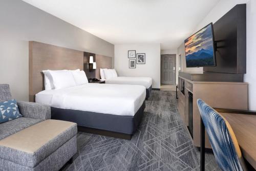 a hotel room with two beds and a flat screen tv at Country Inn & Suites by Radisson Asheville Downtown Tunnel Road in Asheville