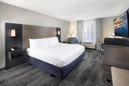 a hotel room with a bed and a desk at Country Inn & Suites by Radisson Asheville Downtown Tunnel Road in Asheville
