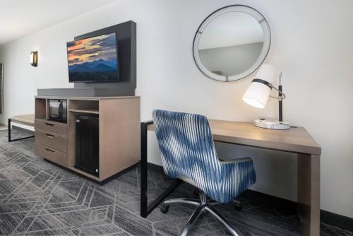 a desk with a mirror and a chair in a room at Country Inn & Suites by Radisson Asheville Downtown Tunnel Road in Asheville