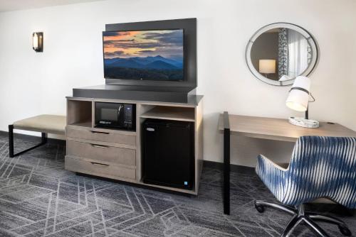 a room with a tv and a desk and a chair at Country Inn & Suites by Radisson Asheville Downtown Tunnel Road in Asheville