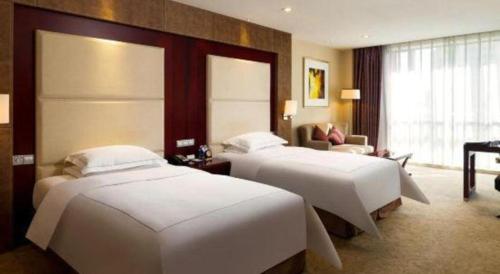 a hotel room with two beds and a piano at Northwest Petroleum Hotel in Ürümqi
