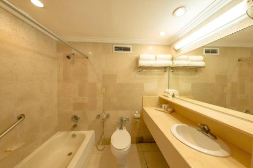 a bathroom with a sink and a toilet and a tub at Hotel El Panama by Faranda Grand, a member of Radisson Individuals in Panama City