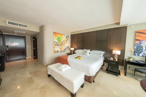 a bedroom with a large white bed and a desk at Hotel El Panama by Faranda Grand, a member of Radisson Individuals in Panama City