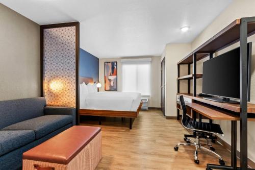 a hotel room with a bed and a desk with a tv at Everhome Suites Yuma East I-8 by Choice Hotels in Yuma