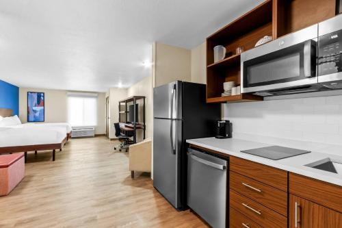 a kitchen with a refrigerator and a bed in a room at Everhome Suites Yuma East I-8 by Choice Hotels in Yuma
