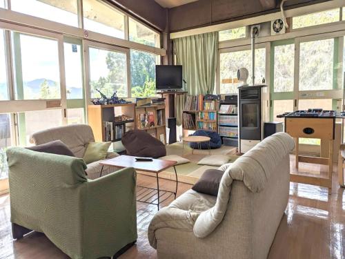 a living room with two couches and a tv at Amanohashidate Youth Hostel - Vacation STAY 94802v in Miyazu