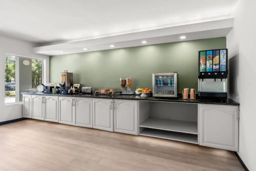 a kitchen with white cabinets and a counter at Quality Inn Orlando Near International Drive in Orlando