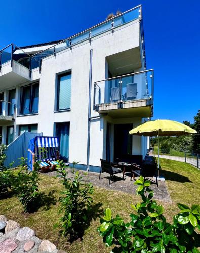 a building with a patio with an umbrella and chairs at Haus Calmsailing in Börgerende-Rethwisch