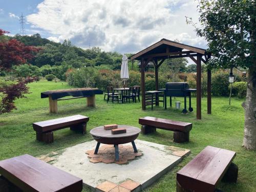 a group of picnic tables and benches in a park at Villa Ashitani - Vacation STAY 08864v in Nantan city