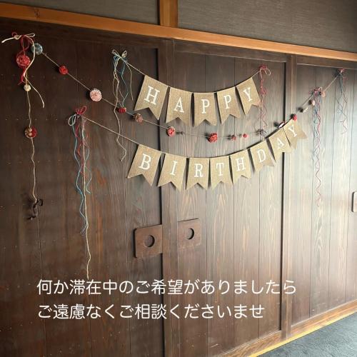 a happy birthday banner hanging on a wooden wall at oyadoyadokari - Vacation STAY 08483v in Okayama