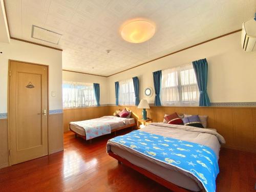 a large bedroom with two beds and a window at Umino House Nagisa - Vacation STAY 95985v in Nanjo
