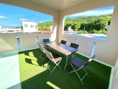 a dining room with a table and chairs and a window at Umino House Nagisa - Vacation STAY 95985v in Nanjo