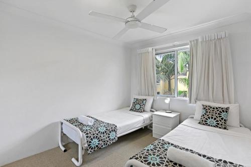 een slaapkamer met twee bedden en een raam bij Le Beach Apartments in Gold Coast