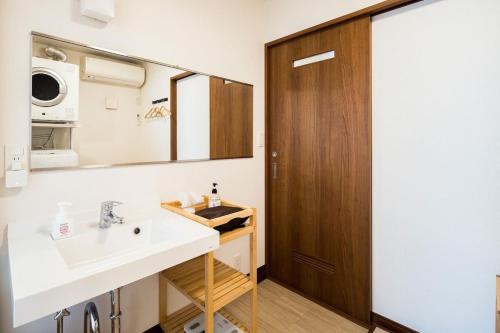 un baño con lavabo y espejo en Oceanfront Villa Hale Kahakai - Vacation STAY 52109v, en Miura