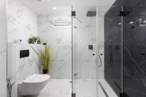Un baño blanco con ducha y WC. en ים סוף - דירת גן מושלמת עם בריכה פרטית למשפחות באילת, en Eilat