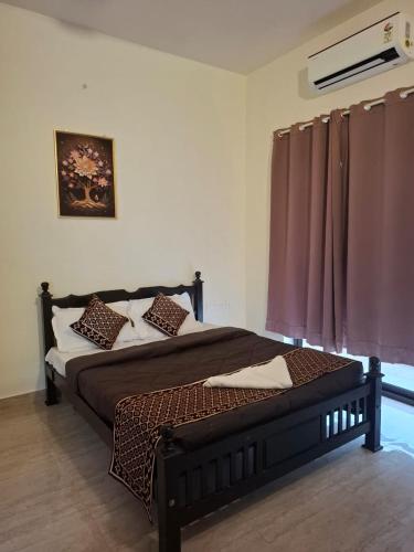a bedroom with a large bed with brown sheets and pillows at Silver Sand Resorts With Private Swimming Pool in Chennai