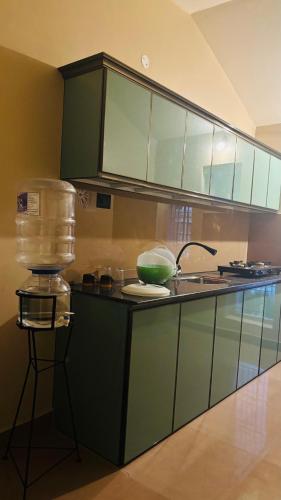 a kitchen with green cabinets and a counter top at Venice villa varkala cliff -luxurious rooms and apartments in Varkala