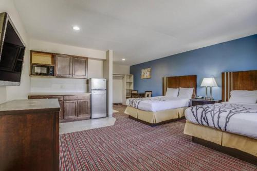 a hotel room with two beds and a kitchen at Econo Lodge Inn & Suites in Enid