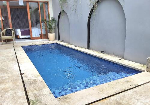 a swimming pool in a yard next to a house at Near to The Beach Ayunjani Villa, Bali in Ketewel