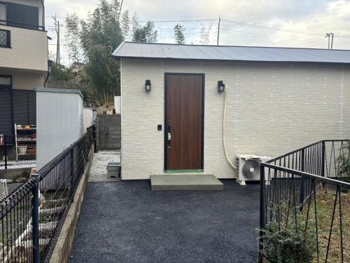 a white house with a brown door and a driveway at Haveanice Havanice - Vacation STAY 15818 in Akiruno