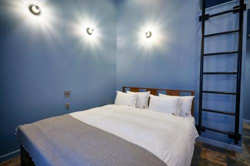a bedroom with a bed with two lights on the wall at COFFEE HOTEL Soundwave - Vacation STAY 17824v in Fujisawa